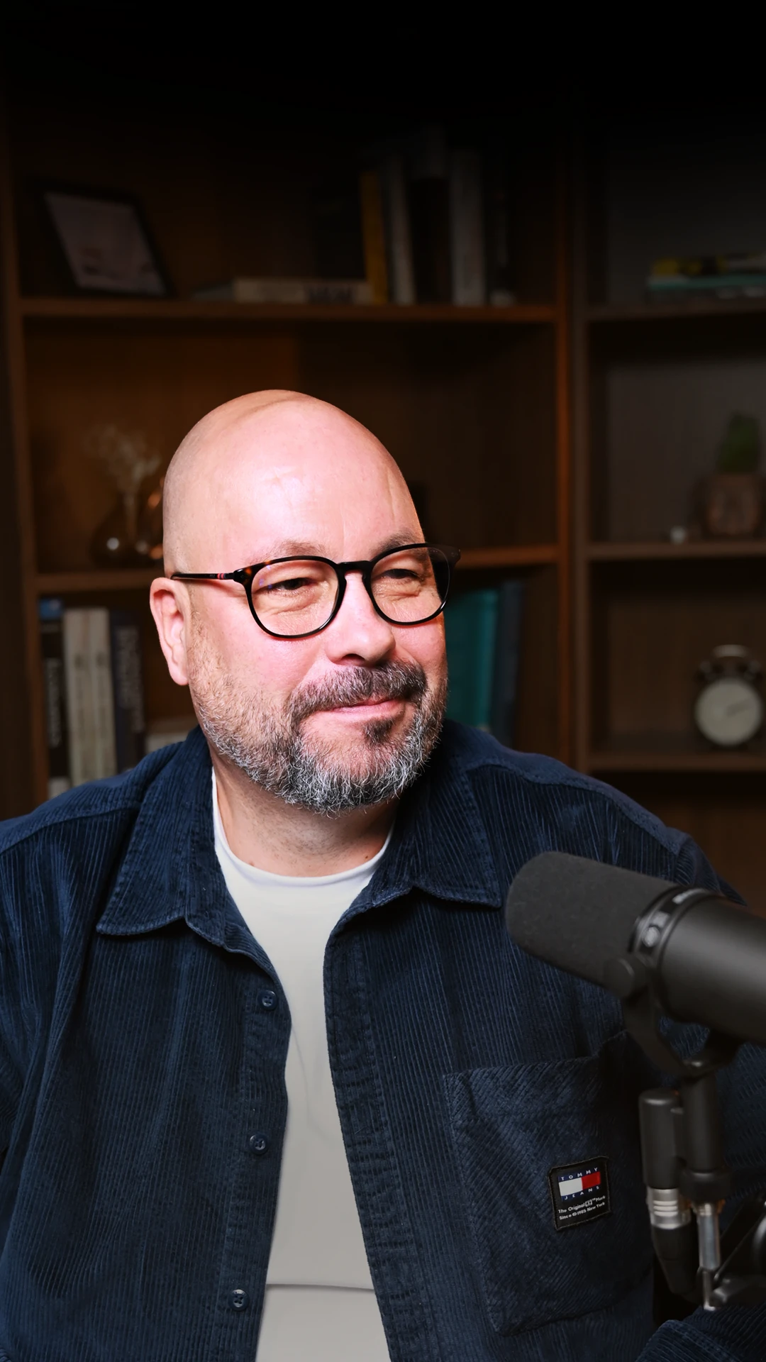 muž v brýlích za mikrofonem